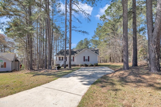 view of front of property featuring covered porch, a front lawn, and concrete driveway