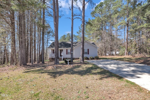 view of front of property featuring concrete driveway, a shingled roof, and a front lawn