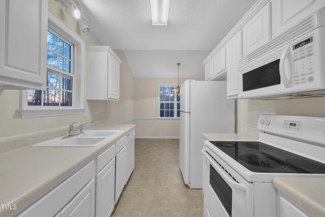 kitchen with white cabinetry, light countertops, a sink, and white appliances