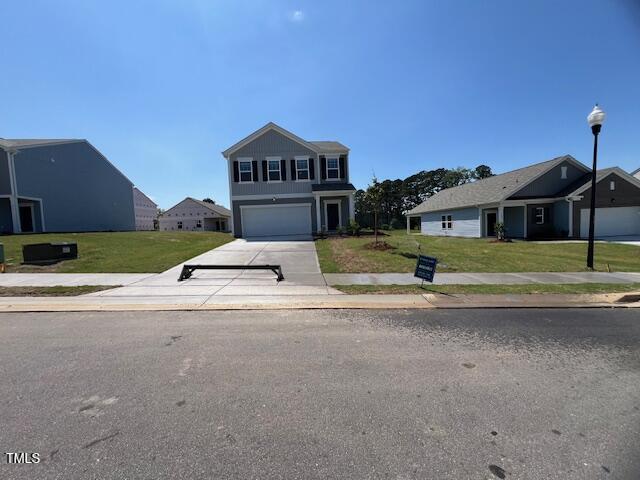 837 Kenyon Spring Dr, Zebulon, NC 27597 - traditional-style house featuring driveway, a front yard, and a garage