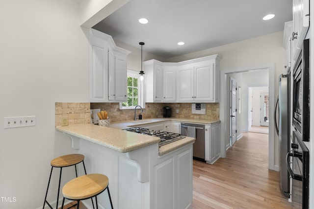 5237 Christian Light Rd, Fuquay Varina, NC 27526 - kitchen featuring a sink, a peninsula, stainless steel appliances, white cabinets, and tasteful backsplash