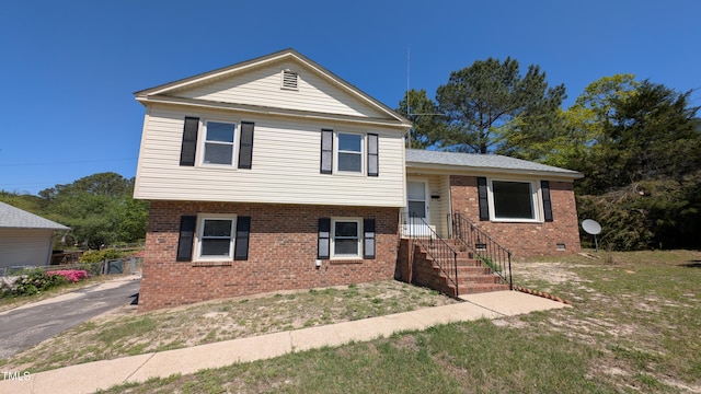 split level home featuring brick siding and fence
