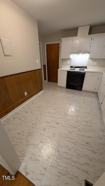 5240 Chesapeake Rd, Fayetteville, NC 28311 - kitchen with gas range, white cabinets, light countertops, light marble finish flooring, and wainscoting