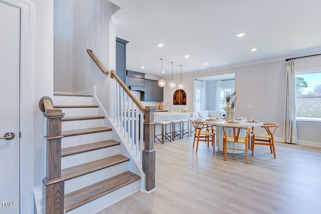 stairs with recessed lighting, baseboards, ornamental molding, and wood finished floors