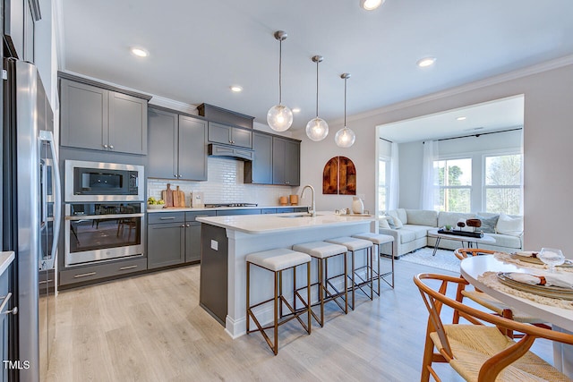 kitchen with tasteful backsplash, light countertops, appliances with stainless steel finishes, and a breakfast bar area