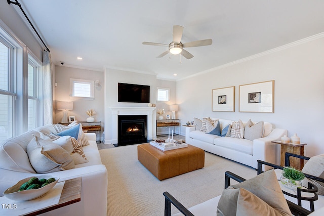 living room featuring ornamental molding, a wealth of natural light, a ceiling fan, and baseboards
