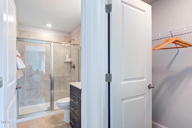 full bathroom with tile patterned flooring, toilet, a stall shower, and vanity