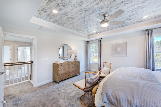 carpeted bedroom featuring recessed lighting, baseboards, and a raised ceiling
