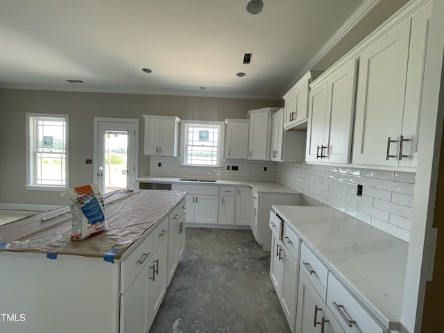 508 S Vance St, Fremont, NC 27830 - kitchen featuring tasteful backsplash, white cabinets, a kitchen island, crown molding, and a sink