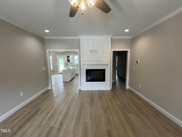 508 S Vance St, Fremont, NC 27830 - unfurnished living room featuring a ceiling fan, recessed lighting, light wood-style floors, crown molding, and a large fireplace