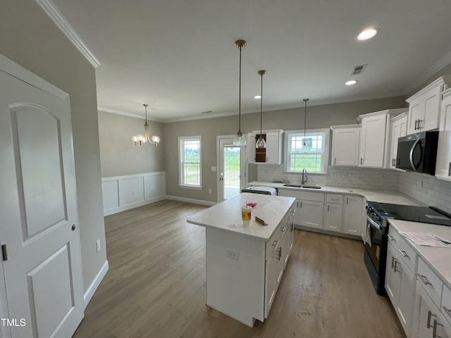 508 S Vance St, Fremont, NC 27830 - kitchen featuring stove, ornamental molding, a center island, tasteful backsplash, and wood finished floors