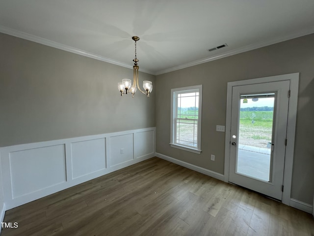 508 S Vance St, Fremont, NC 27830 - unfurnished dining area featuring a chandelier, wood finished floors, ornamental molding, a decorative wall, and a wainscoted wall