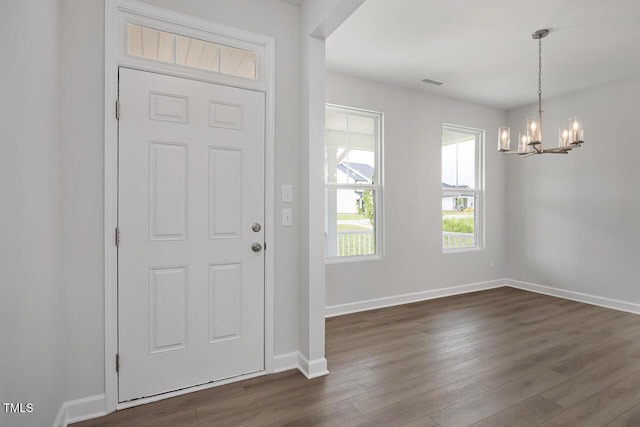 foyer with visible vents, baseboards, a chandelier, and dark wood-type flooring