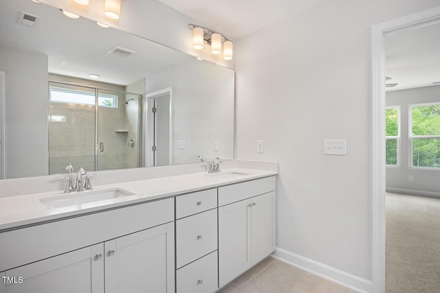 bathroom featuring a stall shower, a sink, baseboards, and visible vents