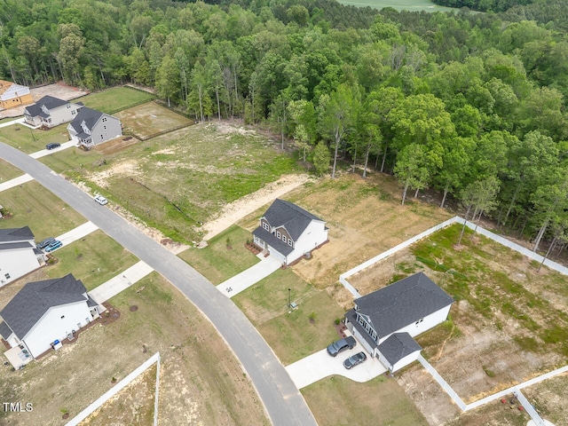 drone / aerial view featuring a residential view and a view of trees