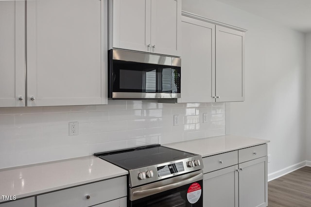 kitchen featuring appliances with stainless steel finishes, light countertops, and decorative backsplash