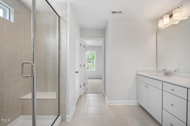 bathroom with a shower stall, vanity, tile patterned floors, visible vents, and baseboards