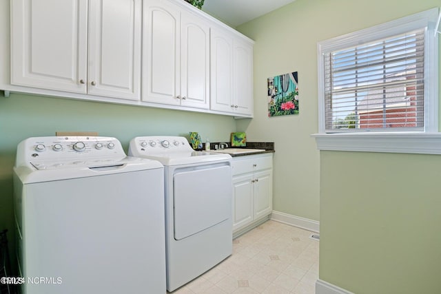 washroom with a sink, washing machine and clothes dryer, light tile patterned floors, baseboards, and cabinet space