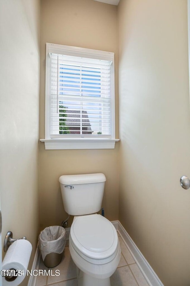 bathroom featuring baseboards, toilet, and tile patterned flooring