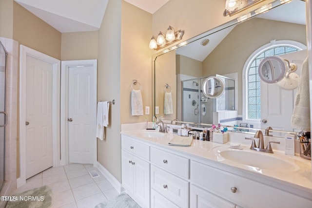 bathroom featuring a shower stall, vaulted ceiling, tile patterned flooring, and a sink