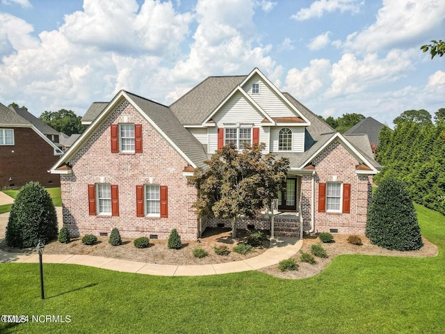 view of front facade with crawl space, a front yard, covered porch, brick siding, and a shingled roof
