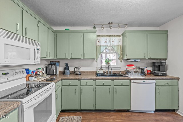 kitchen with dark wood-style floors, white appliances, a sink, and a textured ceiling