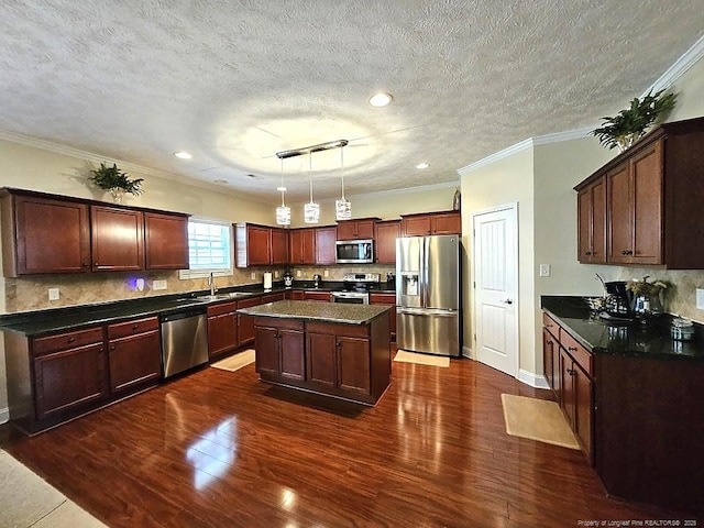 kitchen with dark wood-type flooring, a sink, appliances with stainless steel finishes, and dark countertops