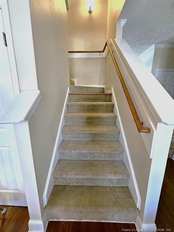 stairway featuring baseboards and wood finished floors