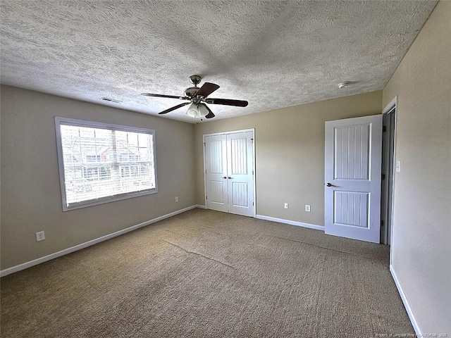 unfurnished bedroom with carpet flooring, a textured ceiling, baseboards, visible vents, and a closet