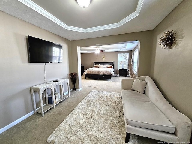 bedroom with carpet flooring, baseboards, crown molding, and a raised ceiling