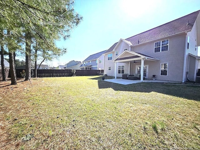 rear view of house with a lawn, a ceiling fan, a patio, and a fenced backyard