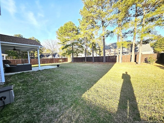 view of yard with a fenced backyard, a ceiling fan, and a patio area