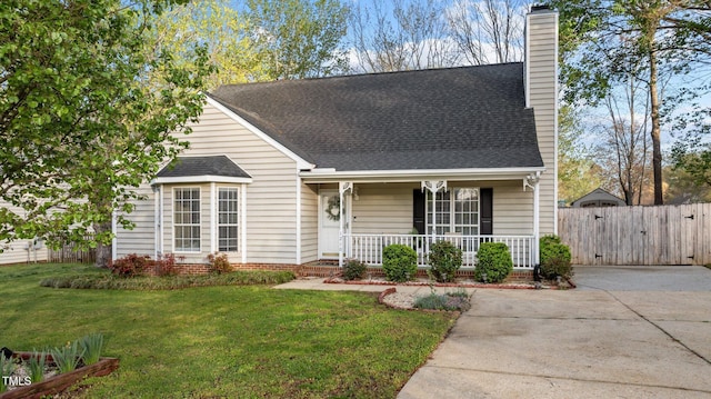 view of front of house featuring fence, a front yard, covered porch, a shingled roof, and a chimney