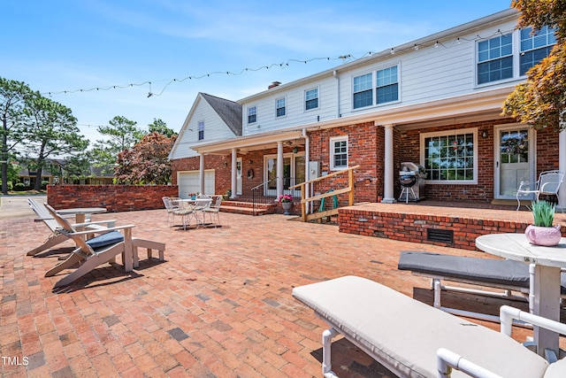 504 W Brocklyn St, Benson, NC 27504 - rear view of property featuring a patio, brick siding, a garage, and outdoor dining space