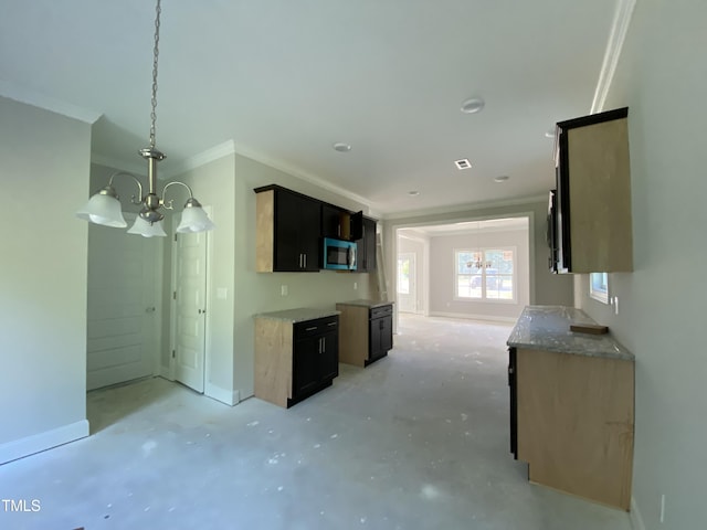 kitchen with an inviting chandelier, crown molding, baseboards, stainless steel microwave, and unfinished concrete flooring