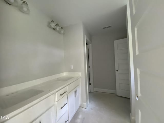 bathroom with double vanity, baseboards, a sink, and visible vents