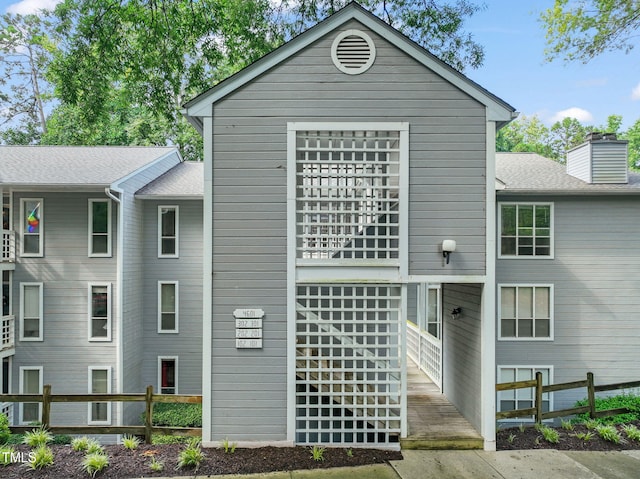 view of front of property with fence and roof with shingles