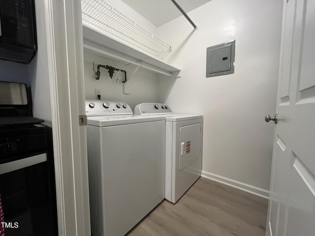 1300 Hillbrow Ln Unit 204, Raleigh, NC 27615 - washroom with electric panel, washing machine and dryer, and light wood-style flooring