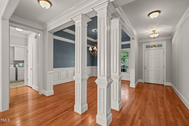 corridor featuring washer and clothes dryer, light wood-style flooring, and ornamental molding