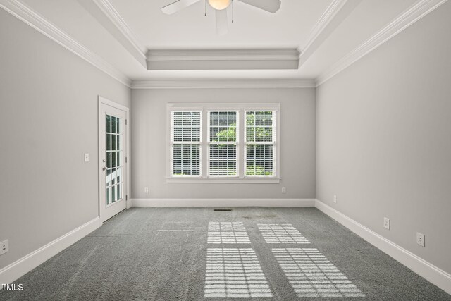 carpeted spare room with a raised ceiling, a ceiling fan, ornamental molding, and baseboards