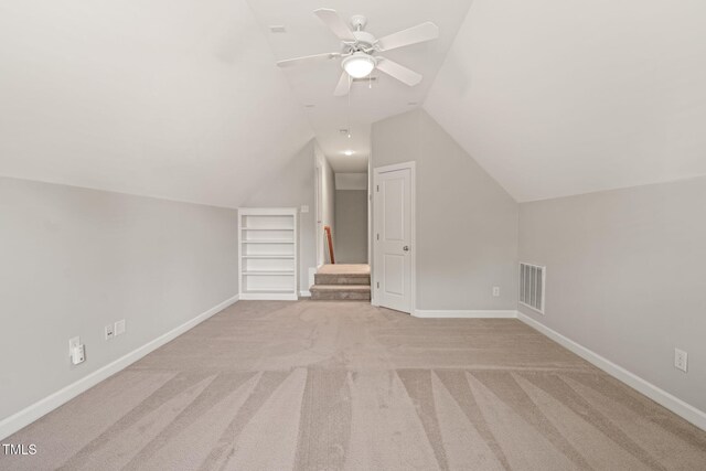 bonus room with vaulted ceiling, ceiling fan, light colored carpet, and baseboards