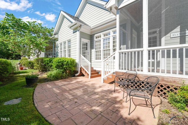 view of patio featuring entry steps and a sunroom