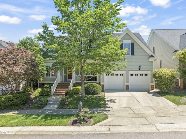 view of property hidden behind natural elements featuring a garage, driveway, brick siding, and covered porch