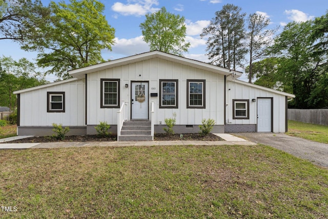 view of front of home featuring board and batten siding, a front lawn, fence, and crawl space
