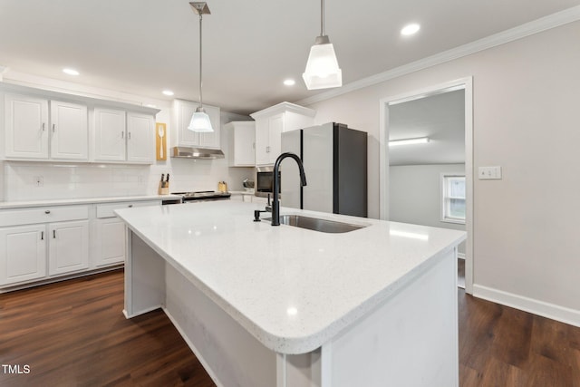 kitchen with crown molding, freestanding refrigerator, tasteful backsplash, white cabinetry, and a sink