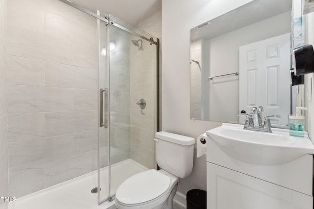 full bathroom with visible vents, toilet, a shower stall, and vanity