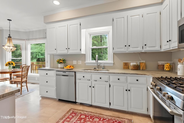 kitchen featuring appliances with stainless steel finishes, a sink, white cabinets, crown molding, and hanging light fixtures