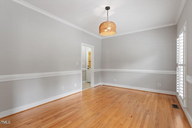 unfurnished room with wood finished floors, baseboards, and crown molding