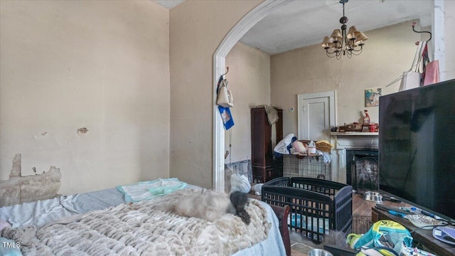 410 Halifax St, Warrenton, NC 27589 - bedroom featuring arched walkways, a high ceiling, a fireplace, and a notable chandelier