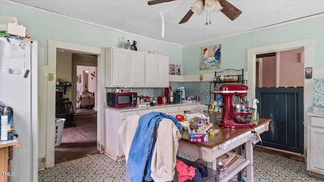 410 Halifax St, Warrenton, NC 27589 - kitchen featuring ornamental molding, light countertops, a ceiling fan, white cabinetry, and decorative backsplash
